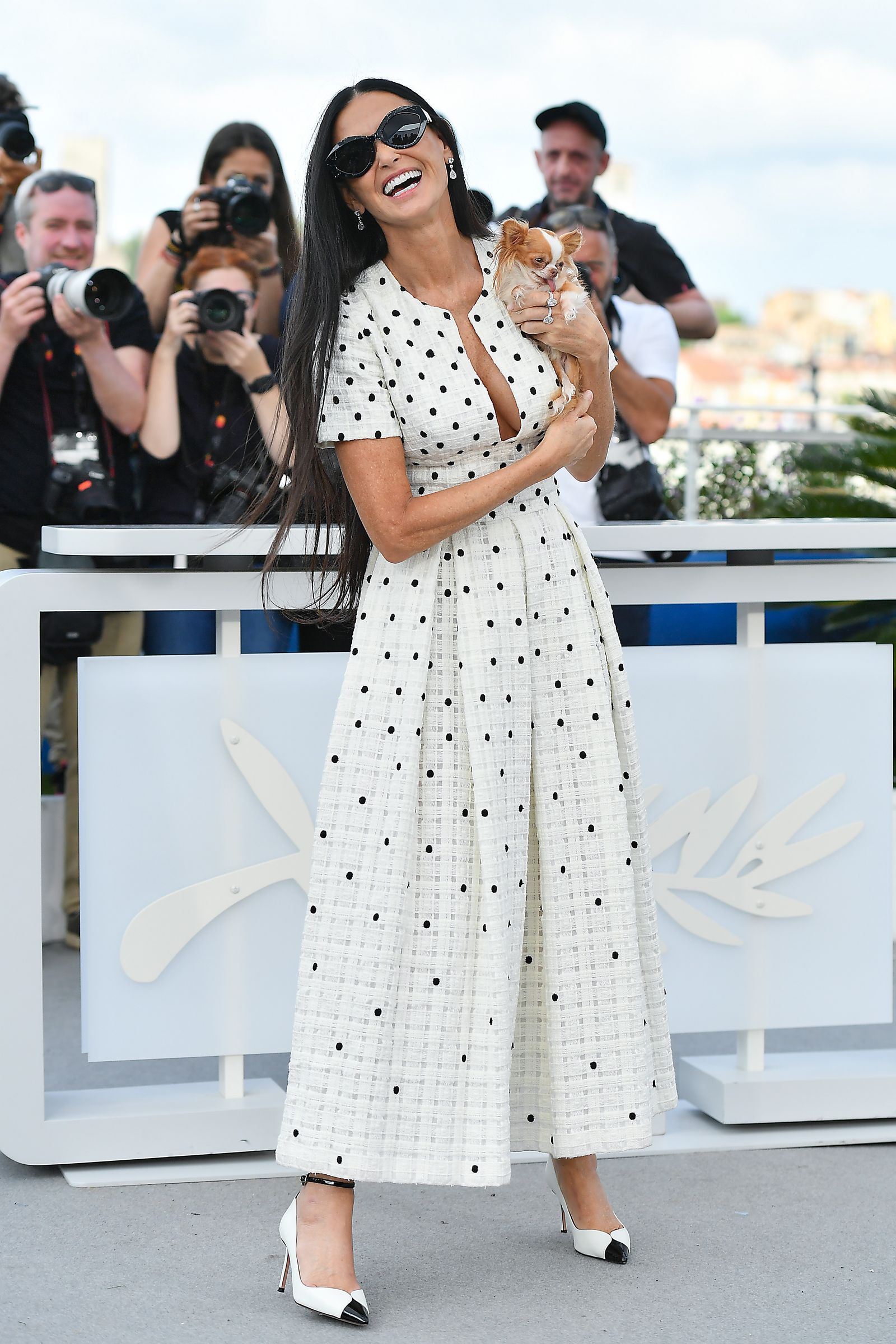 Pilaf held up in front of a line of press photographers on a bright day.